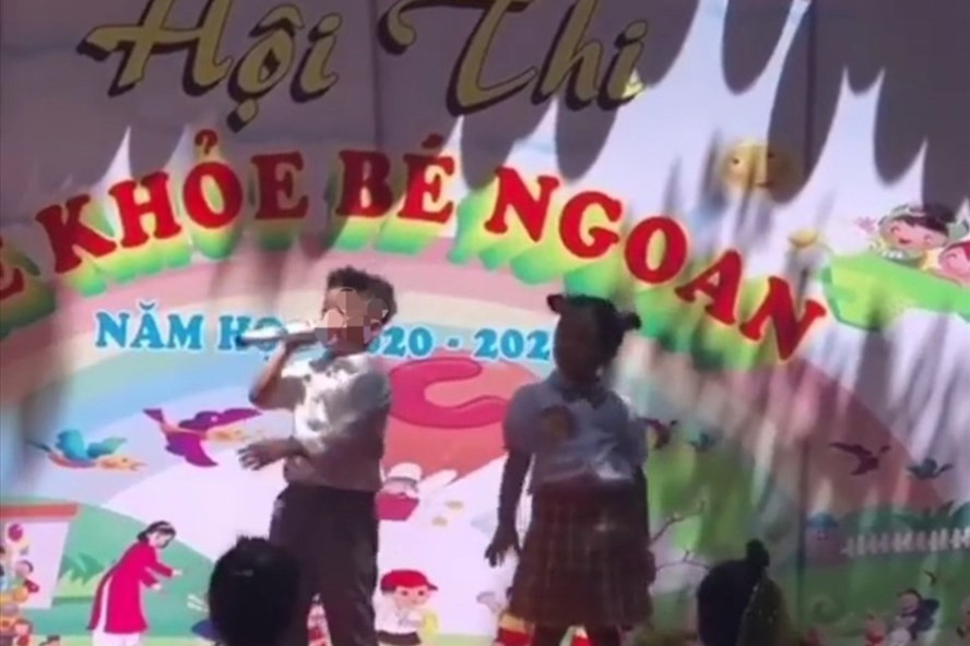Hai bé đang theo học Trường Mầm non Hoa Sen (TP.Buôn Ma Thuột, tỉnh Đắk Lắk) hát trên sân khấu nhạc không phù hợp với lứa tuổi. Ảnh: Cắt từ clip