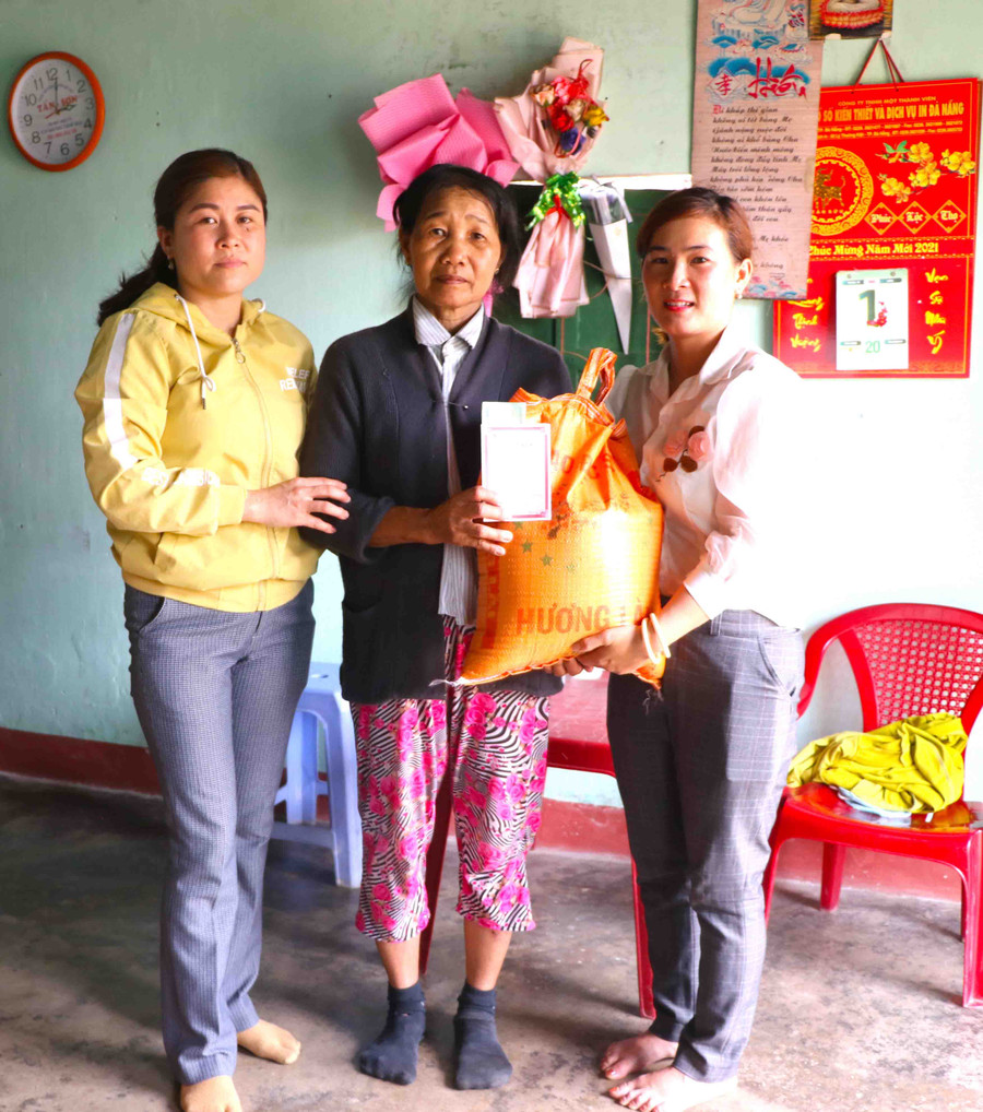 Gia đình bà Nguyễn Thị Giá (đứng giữ; thôn An Hòa) được Hội LHPN xã Phú An tặng gạo và sổ tiết kiệm. Ảnh Ngọc Minh