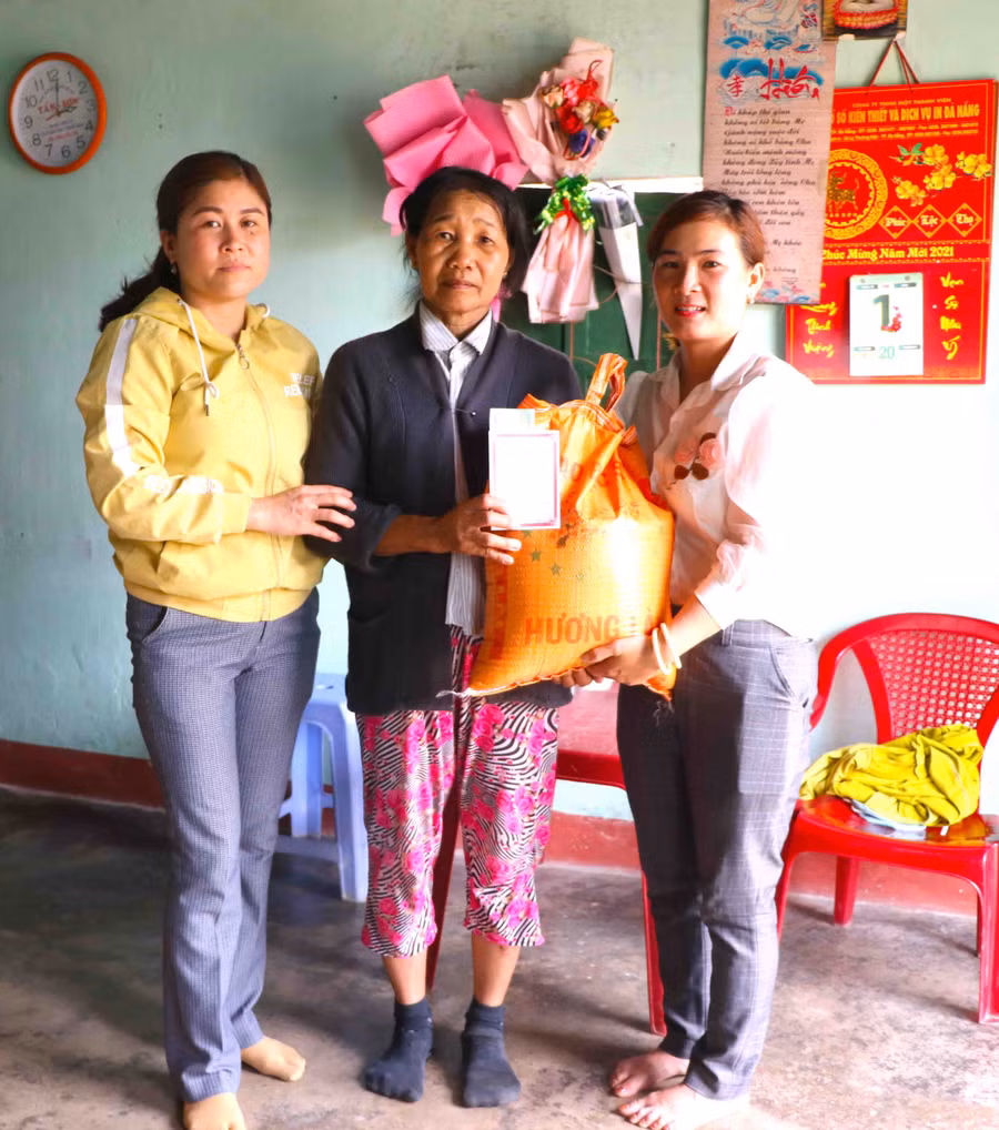 Gia đình bà Nguyễn Thị Giá (đứng giữ; thôn An Hòa) được Hội LHPN xã Phú An tặng gạo và sổ tiết kiệm. Ảnh Ngọc Minh