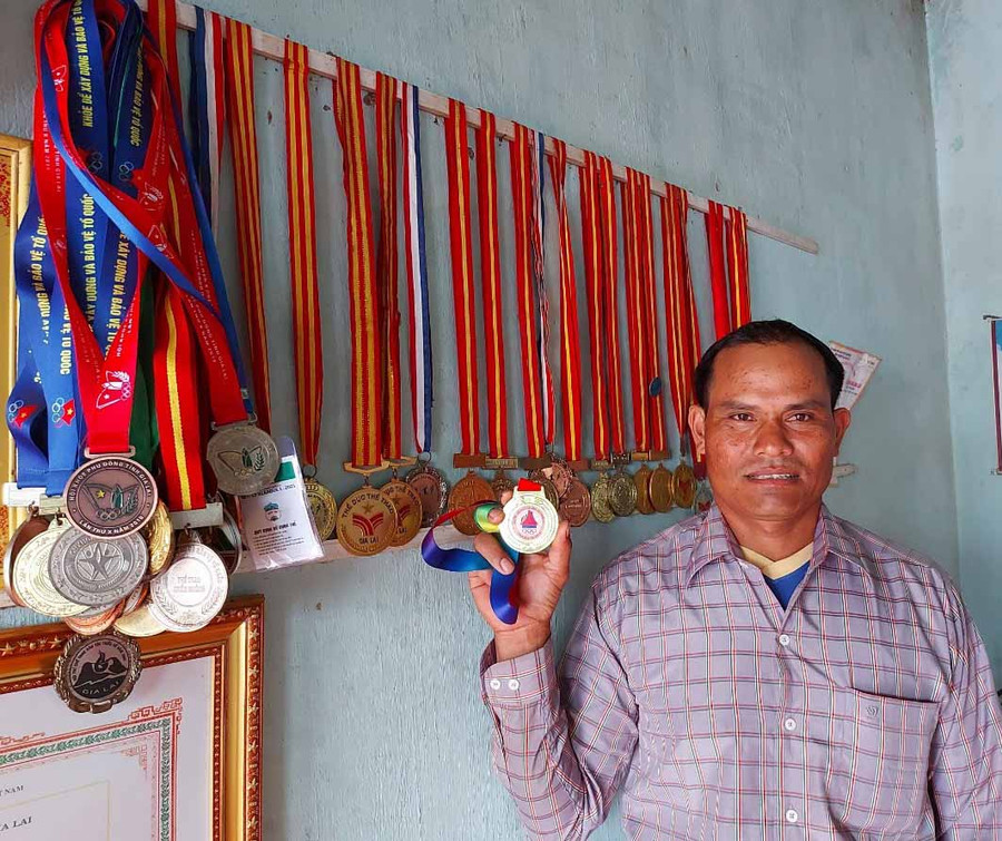 5. Anh Puih Tum bên những tấm huy chương đã giành được ở các giải đấu trong và ngoài tỉnh. Ảnh T.D
