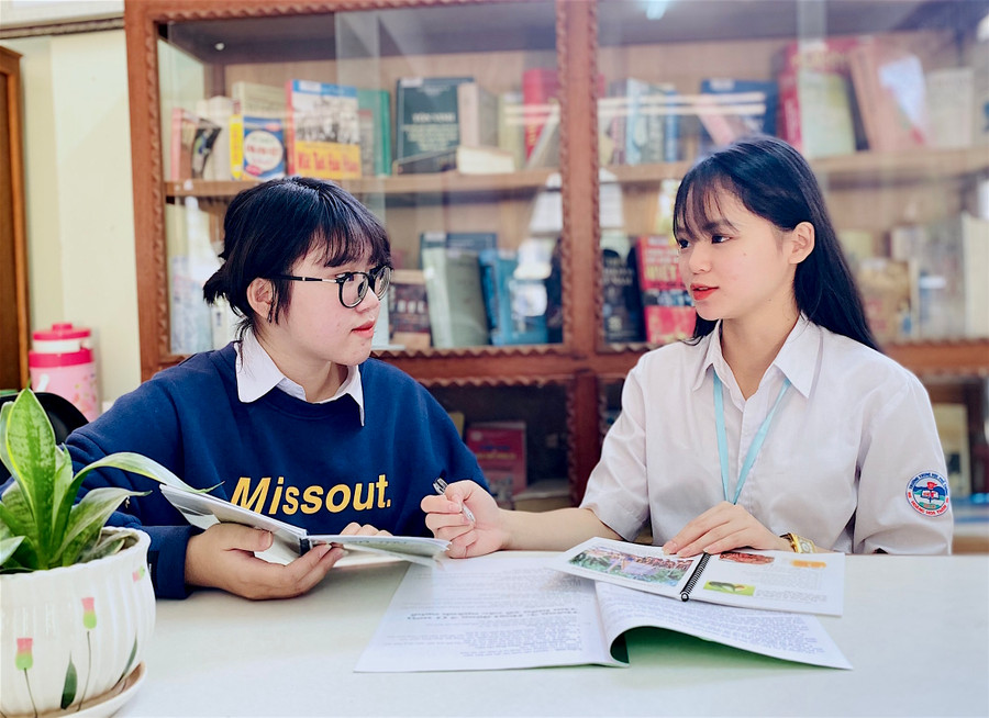 Em Nguyễn Thị Minh Khánh (bìa phải) và Nguyễn Thị Thanh Huyền (Trường THPT Hoàng Hoa Thám, TP. Pleiku) trao đổi để hoàn chỉnh cuốn “Cẩm nang du lịch phía Bắc TP. Pleiku-Gia Lai”. Ảnh: M.T