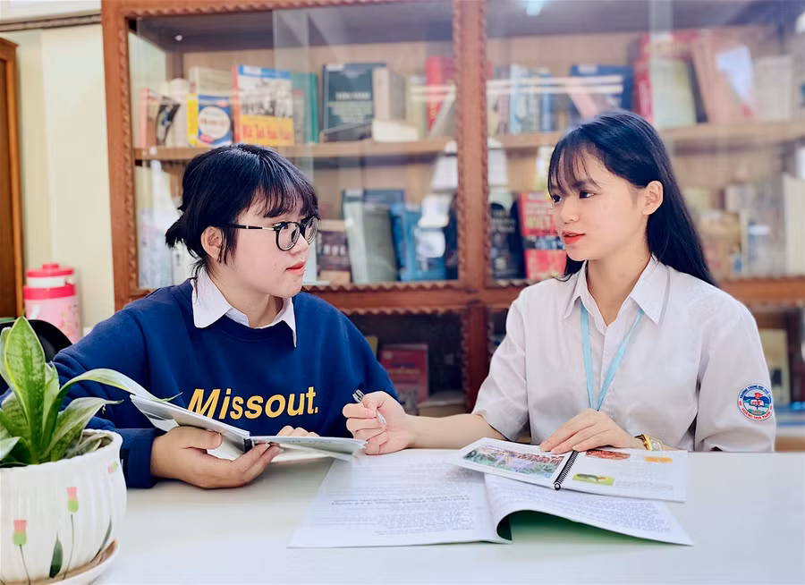 Em Nguyễn Thị Minh Khánh (bìa phải) và Nguyễn Thị Thanh Huyền (Trường THPT Hoàng Hoa Thám, TP. Pleiku) trao đổi để hoàn chỉnh cuốn “Cẩm nang du lịch phía Bắc TP. Pleiku-Gia Lai”. Ảnh: M.T