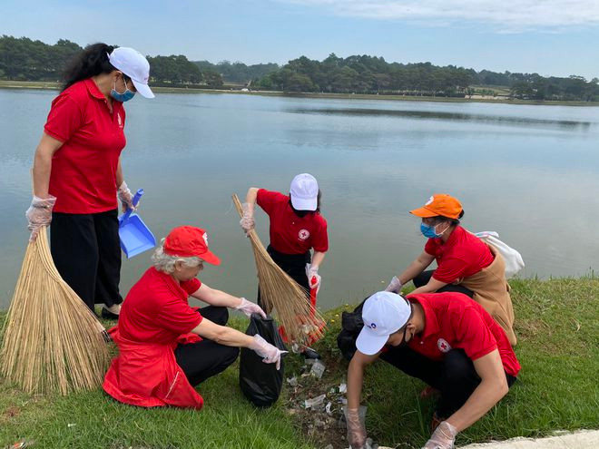 Hội viên Hội Chữ thập đỏ thu gom rác quanh hồ Xuân Hương. ẢNH: LÂM VIÊN