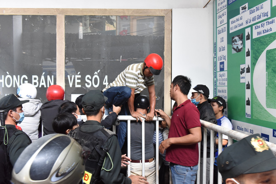 Một cổ động viên mua được vé nhưng không có lối ra vì dòng người kẹt cứng nên phải trèo qua hàng rào.