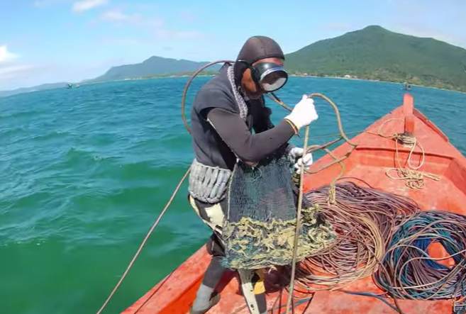 Ông Tư chuẩn bị cho pha lặn biển tìm cá.