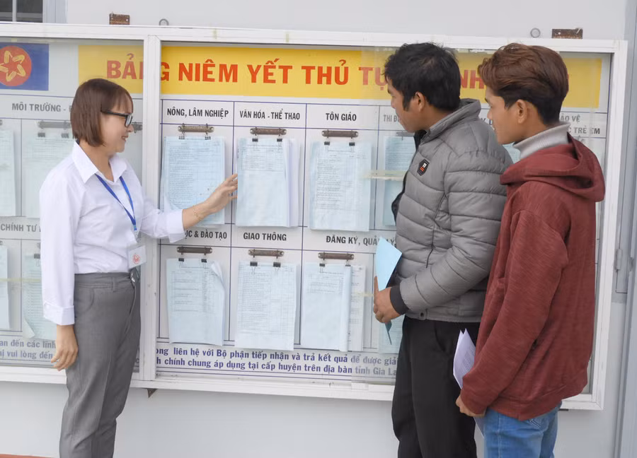 Cán bộ xã Đak Ta Ley (huyện Mang Yang) hướng dẫn người dân tìm hiểu các TTHC đã được niêm yết. Ảnh: Thanh Nhật 