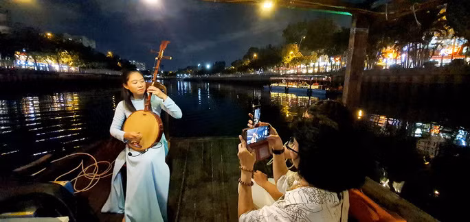 Du khách nghe đàn trên kênh Nhiêu Lộc - Thị Nghè