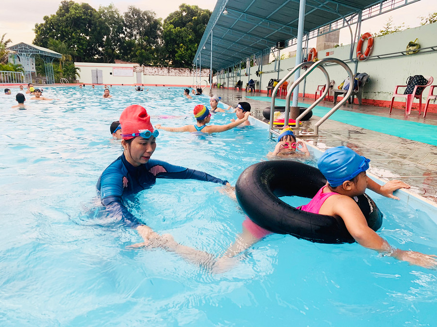 Giáo viên hướng dẫn các em cách đạp chân khi bơi. Ảnh: Vũ Chi