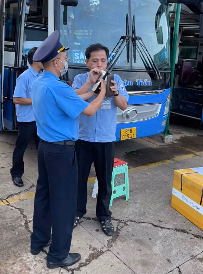 Lực lượng Thanh tra Giao thông đo nồng độ cồn đối với lái xe trước khi xuất bến. Ảnh: Lê Anh