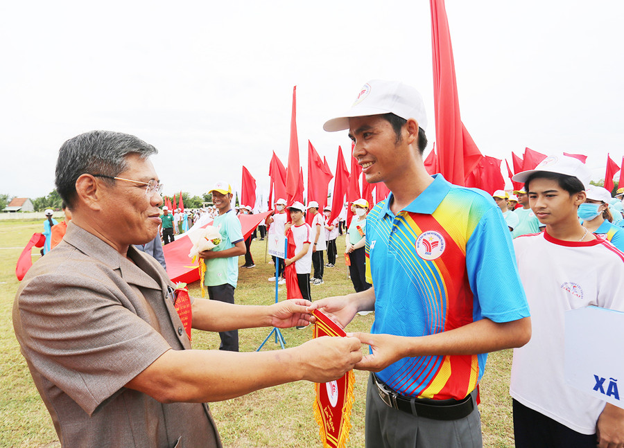 Bí thư Huyện ủy Tô Văn Chánh tặng hoa và cờ lưu niệm cho đại diện các đoàn tham gia Đại hội. Ảnh: Văn Ngọc