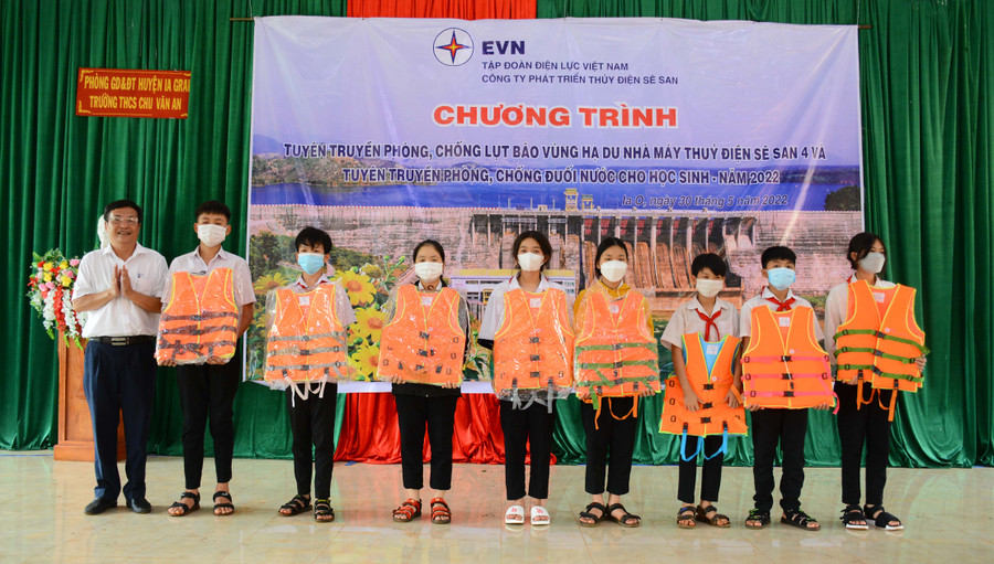 Đại diện Công ty Phát triển thủy điện Sê San tặng áo phao cho các em học sinh. Ảnh: Minh Nguyễn
