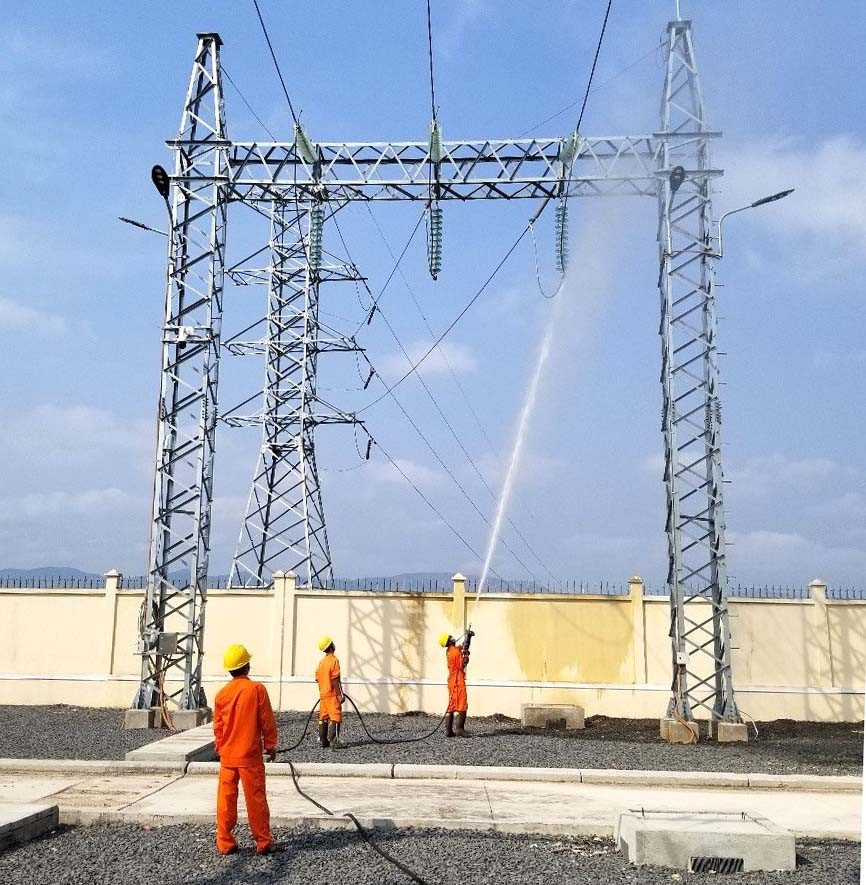 Công nhân ngành Điện vệ sinh sứ TBA bằng công nghệ hotline. Ảnh: Khang Nghi