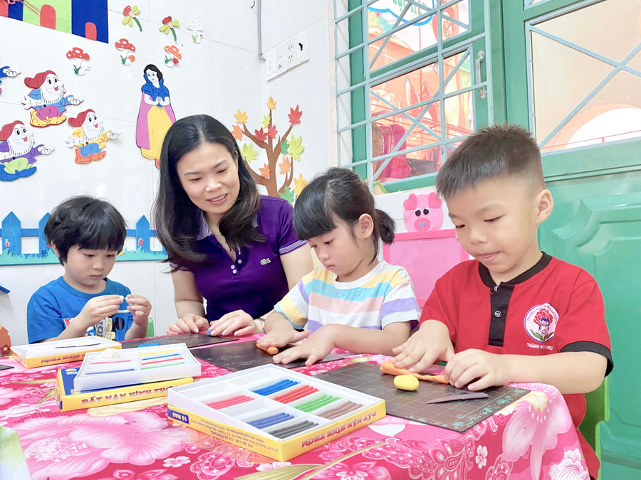 Cô Nguyễn Thị Lê Na-giáo viên Trường Mầm non Hoa Hồng (phường Hội Thương, TP. Pleiku) hướng dẫn trẻ tạo hình trong một giờ học hè. Ảnh: Mộc Trà