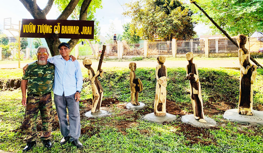 Người dân chụp ảnh tại “Vườn tượng gỗ Bahnar, Jrai”. Ảnh: Bá Bính  “Vườn tượng gỗ Bahnar, Jrai