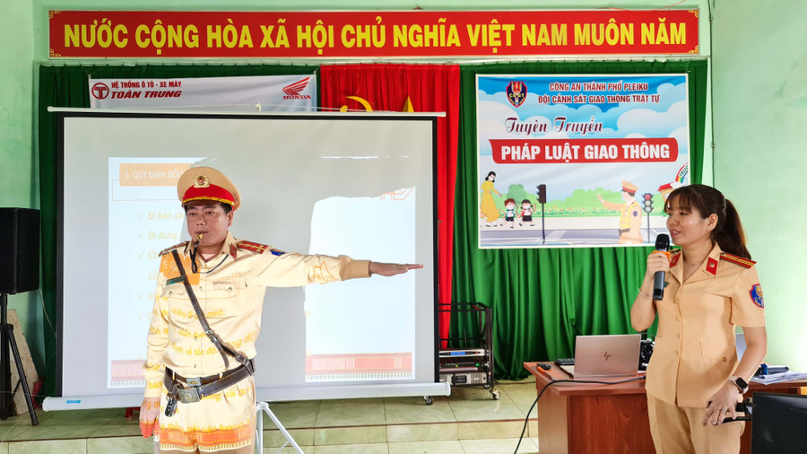 Cán bộ đội CSGT-TT Công an TP. Pleiku hướng dẫn người dân cách nhận biết các hiệu lệnh của người điều khiển giao thông. Ảnh: Bá Bính