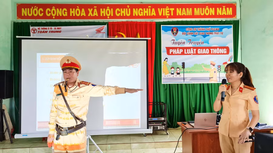 Cán bộ đội CSGT-TT Công an TP. Pleiku hướng dẫn người dân cách nhận biết các hiệu lệnh của người điều khiển giao thông. Ảnh: Bá Bính