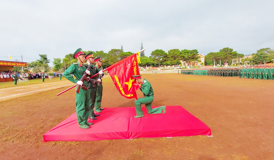 Chiến sĩ mới tuyên thệ và hôn lên lá Quân kỳ của Trung đoàn 48. Ảnh: Vĩnh Hoàng