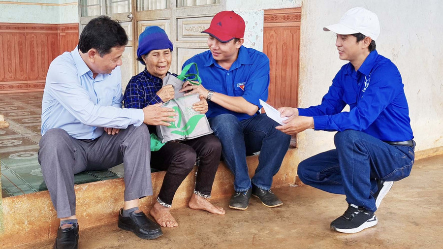 Anh Thái Giang Nam (thứ 2 từ phải sang)-Phó Bí thư Thành Đoàn Pleiku tặng quà cho gia đình chính sách ở xã Gào. Ảnh: Mộc Trà