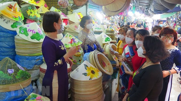 Tiểu thương chợ Đông Ba mặc áo dài nhưng vẫn thực hiện đeo khẩu trang. (Ảnh: Tường Vi/TTXVN) Tiểu thương chợ Đông Ba mặc áo dài nhưng vẫn thực hiện đeo khẩu trang. (Ảnh: Tường Vi/TTXVN)