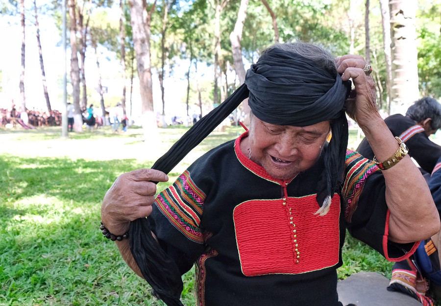 Già làng Rơ Ô Bhung thành thục vấn chiếc khăn của văn hóa Chăm. Ảnh: Hoàng Ngọc