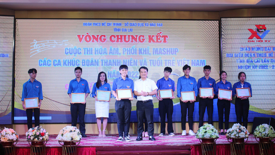 Anh Đỗ Duy Nam (hàng trước, bìa phải) trao giải nhất cho đội thi Đoàn trường THPT Lê Thánh Tông (thị xã Ayun Pa). Ảnh: Phan Lài