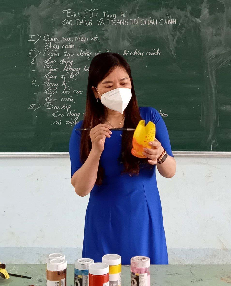 Cô Đặng Thị Mỹ Dung-giáo viên Trường THCS và THPT Kon Hà Nừng (huyện Kbang) hướng dẫn học sinh làm chậu hoa từ chai nhựa. Ảnh: Mộc Trà