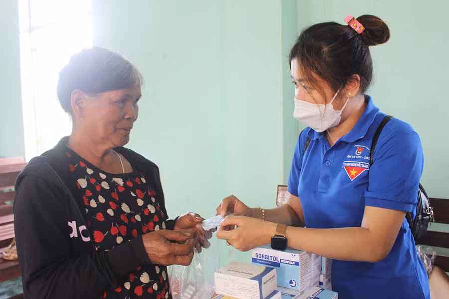 Thành viên Câu lạc bộ Thầy thuốc trẻ huyện Chư Păh hướng dẫn người dân làng Mun (thị trấn Ia Ly) sử dụng thuốc điều trị bệnh. Ảnh: Phan Lài