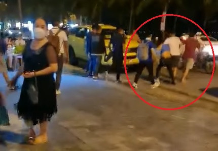 Hướng dẫn viên bị kẹp cổ, lôi từ vỉa hè khách sạn băng qua đường Võ Nguyên Giáp để hành hung. Ảnh: VĂN TIẾN