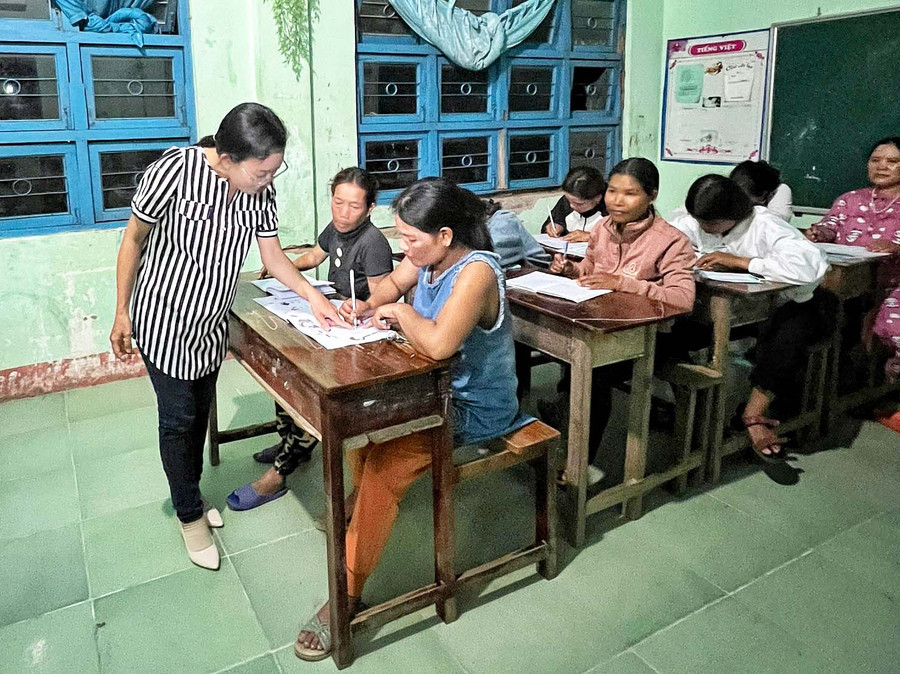 Bà Nguyễn Thị Phúc-công chức Tuyên giáo-Dân vận xã Phú An tình nguyện đứng lớp xóa mù chữ cho phụ nữ làng Đê Chơ Gang. Ảnh: Hoàng Ngọc