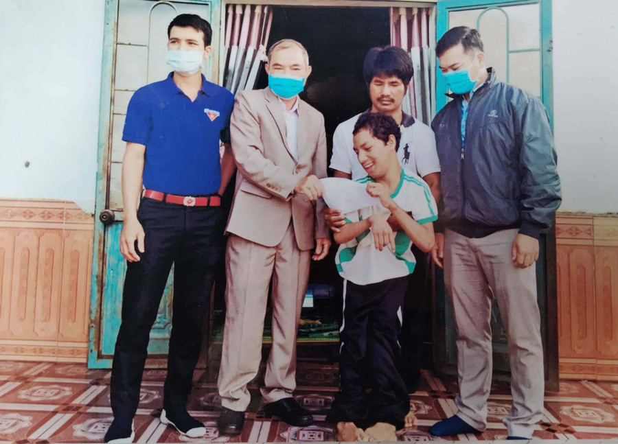 Ông Đặng Xuân Tâm (thứ 2 từ trái sang)-Chủ tịch HộiNNCĐDC/dioxin xã Chư Pơng (huyện Chư Sê) tặng quà cho anh Rơ Lan Jú (làng Hố Lâm). Ảnh: Hoàng Cư