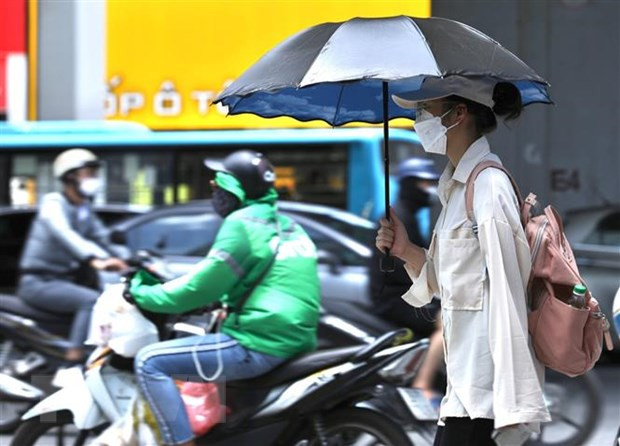  Người dân di chuyển dưới trời nắng nóng tại Hà Nội. (Ảnh: Hoàng HiếuTTXVN)