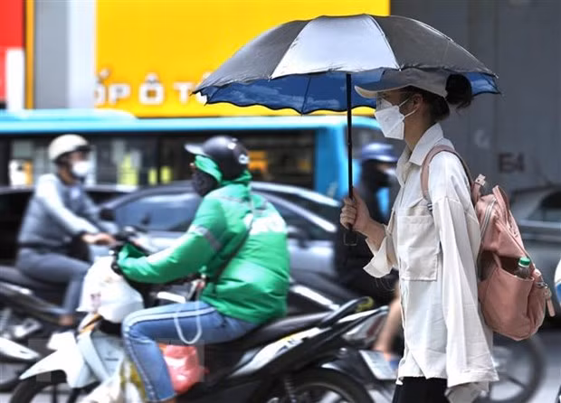 Người dân di chuyển dưới trời nắng nóng tại Hà Nội. (Ảnh: Hoàng HiếuTTXVN) Người dân di chuyển dưới trời nắng nóng tại Hà Nội. (Ảnh: Hoàng HiếuTTXVN)