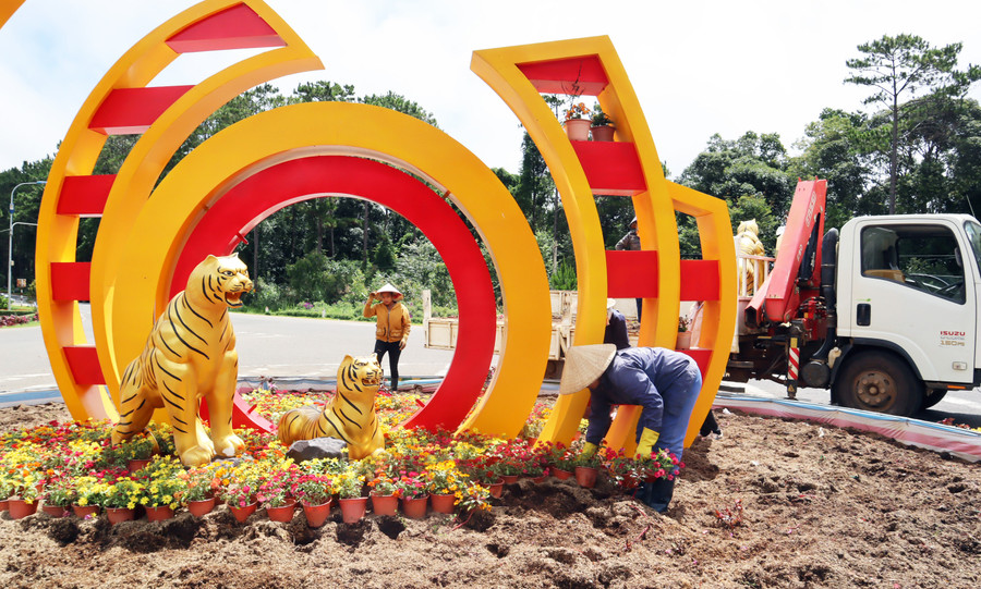  Nhân viên Trung tâm MT&DVĐT huyện Kon Plông cải tạo các giỏ hoa tạo cảnh quan ở vòng xoay đầu đèo Măng Đen. Ảnh: TN