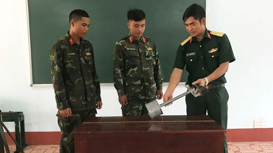 Đại úy Hoàng Văn Thanh hướng dẫn đồng đội cách sử dụng thiết bị hiệu chỉnh súng, pháo 100 trên xe tăng T54. Ảnh: Vĩnh Hoàng