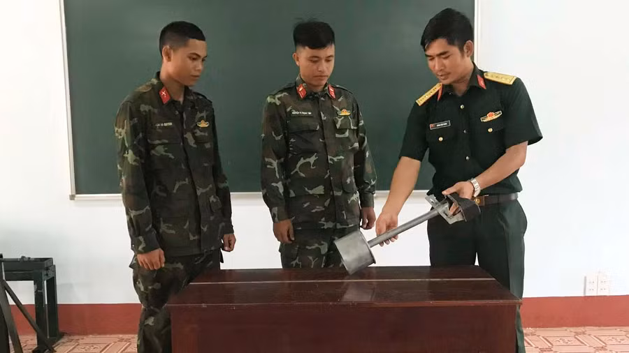 Đại úy Hoàng Văn Thanh hướng dẫn đồng đội cách sử dụng thiết bị hiệu chỉnh súng, pháo 100 trên xe tăng T54. Ảnh: Vĩnh Hoàng