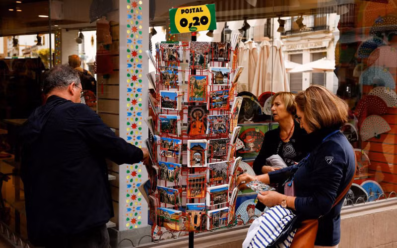 Du khách tại một cửa hàng lưu niệm tại Ronda, Tây Ban Nha hồi tháng 4 năm nay. Ảnh: REUTERS