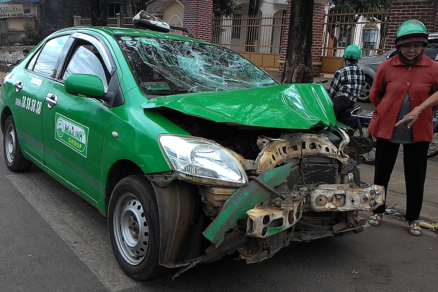 Phần đầu xe taxi biến dạng sau khi đấu đầu với xe mô tô. Ảnh: Nguyễn Giác Phần đầu xe taxi biến dạng sau khi đấu đầu với xe mô tô. Ảnh: Nguyễn Giác