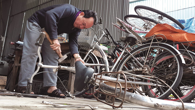 Ông Trần Trung Thực ráp xe đạp cũ thành xe đạp như mới tặng học sinh nghèo.
