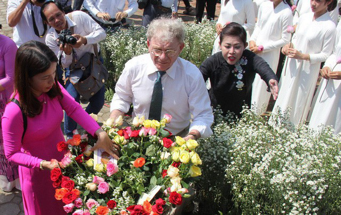 Ông Kelly với những đóa hoa hồng được gửi đến vong linh những thường dân vụ thảm sát.