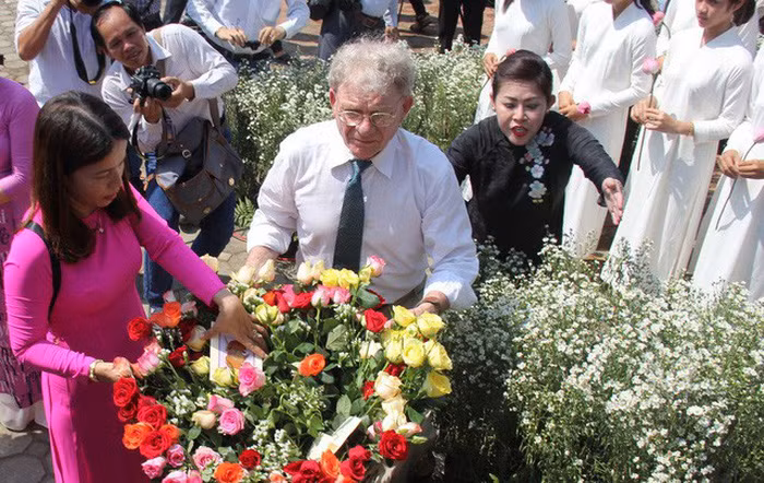 Ông Kelly với những đóa hoa hồng được gửi đến vong linh những thường dân vụ thảm sát.