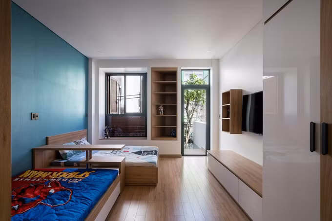 Gia chủ yêu cầu nhà đơn giản nhưng phải có nhiều chỗ chơi cho hai con. Ngoài các khoảng sân quanh giếng trời, phòng của các bé cũng có ban công rộng bên ngoài.