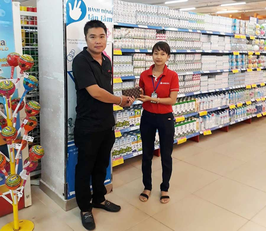  Chị Hương trao lại chiếc ví cho khách hàng đánh rơi. Ảnh: Lê Lan