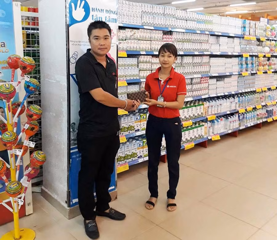  Chị Hương trao lại chiếc ví cho khách hàng đánh rơi. Ảnh: Lê Lan