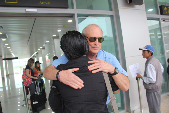 Ông Ronald ôm chầm con của một người may mắn thoát chết trong vụ thảm sát 50 năm về trước khi vừa bước xuống sân bay.