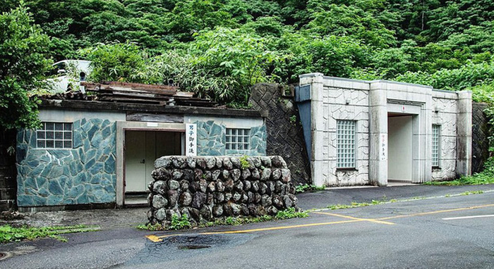 Cây xanh tươi tốt bao quanh nhà vệ sinh công cộng đẹp mắt gần đền Mont Yudono, một điểm nóng du lịch của Tokyo.