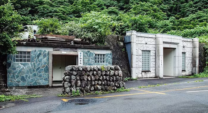 Cây xanh tươi tốt bao quanh nhà vệ sinh công cộng đẹp mắt gần đền Mont Yudono, một điểm nóng du lịch của Tokyo.