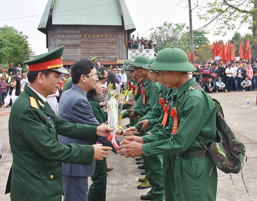 Lãnh đạo huyện Đức Cơ tặng hoa cho các thanh niên lên đường nhập ngũ. Ảnh: Văn Ngọc