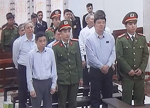 Bảy bị cáo tại phiên tòa, ông Đinh La Thăng đứng ở hàng ghế đầu. Ảnh chụp qua màn hình