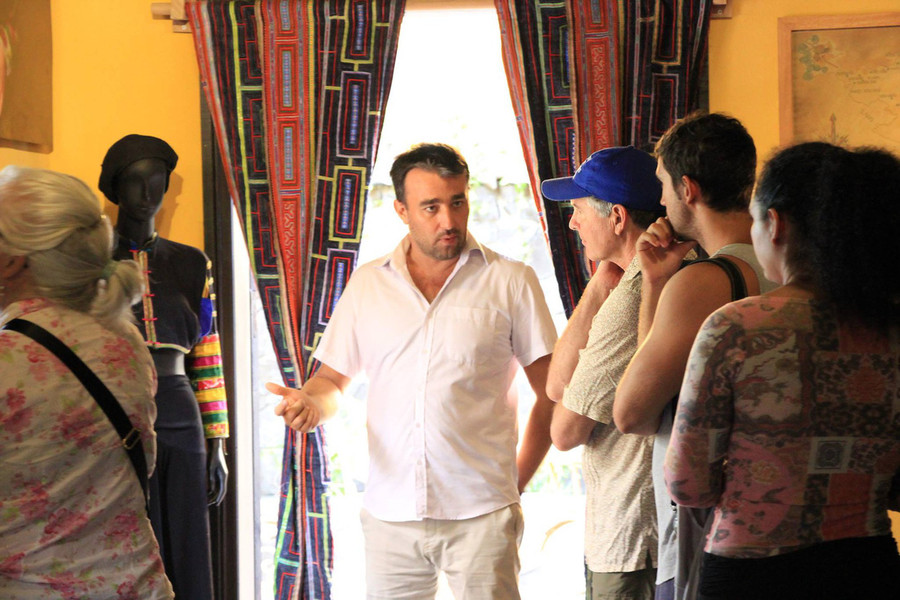 Nhiếp ảnh gia Réhahn nói chuyện với du khách nước ngoài tham quan Bảo tàng Di sản vô giá của anh ở Hội An