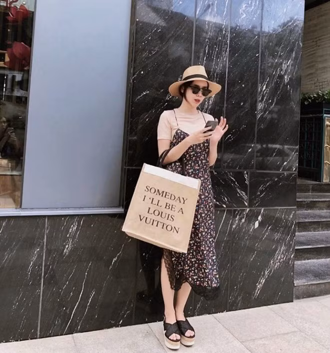  Đầm hai dây in hoa nhí và áo thun ngắn tay, điểm thêm mũ vành tròn và sandals giúp Lưu Hương Giang trẻ trung hơn tuổi.